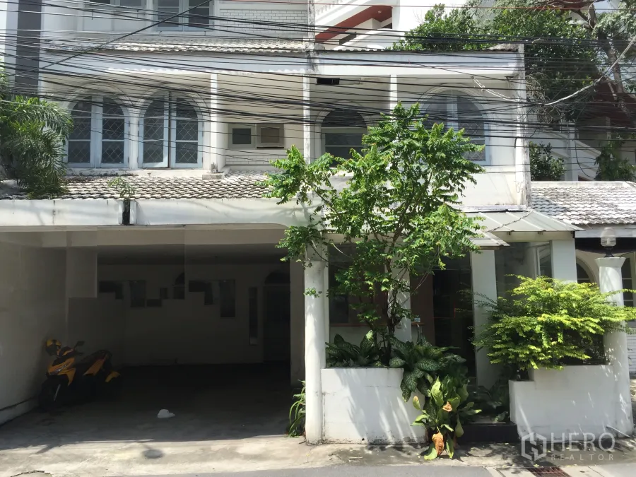 Retail Space for rent in Watthana, Bangkok - Street-facing white low-rise building with arched windows, a covered carport, and leafy planters, ideal for retail near BTS Thonglor.
