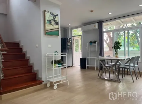 独立式住宅 出租或出售在Lat Phrao, Bangkok - 开放式餐区与木楼梯，落地玻璃门直通花园。