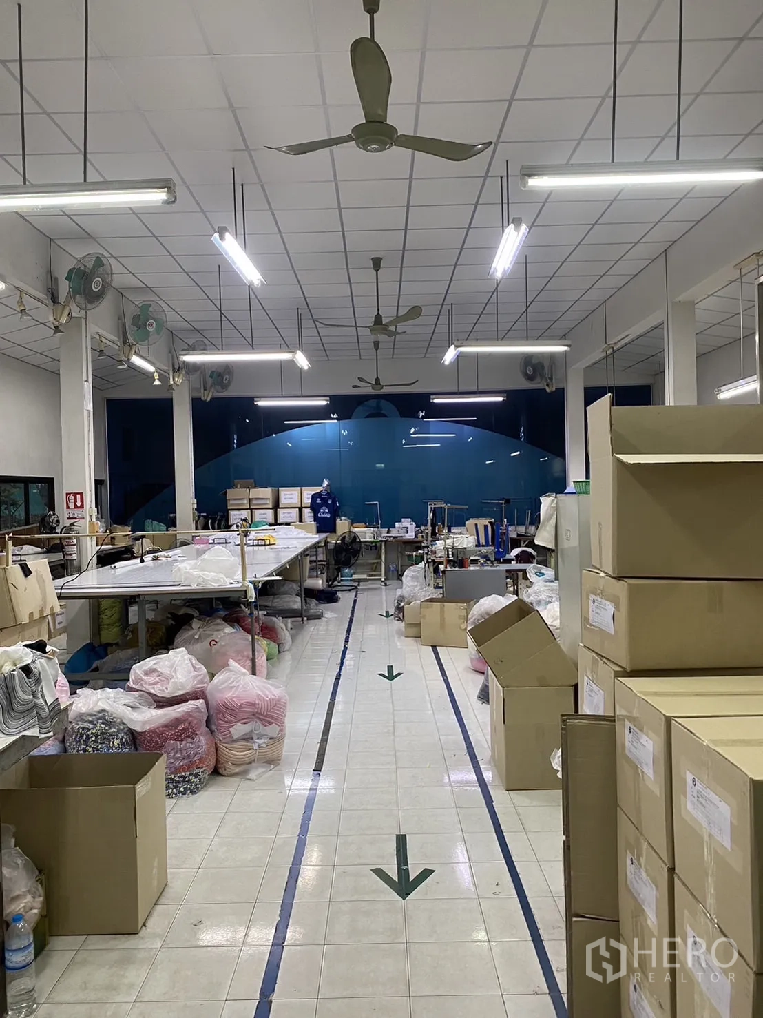 Factory for rent in Prawet, Bangkok - Central aisle of the production floor with marked walkways, boxes and materials.