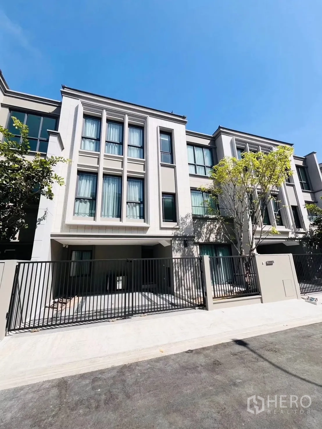 联排别墅 for rent in Suan Luang, Bangkok - 现代联排别墅外立面，落地窗与带门庭的围栏。