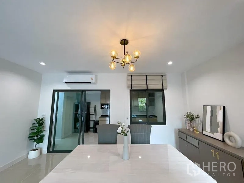 联排别墅 出租在Bang Phli, Samut Prakan - 餐区设吊灯、边柜，推拉门通往厨房。