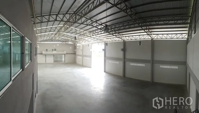 Factory for sale in Bang Sao Thong, Samut Prakan - Warehouse interior showing high ceiling, skylights and large loading access.