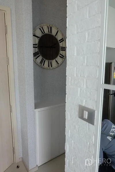 Condominium for rent in Khlong Toei, Bangkok - Decor corner with large vintage wall clock and built-in cabinet near the kitchen.