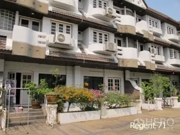 Townhouse for rent in Khlong Toei, Bangkok - Close-up of townhouse facades with balconies, outdoor plants, and air-conditioning units.