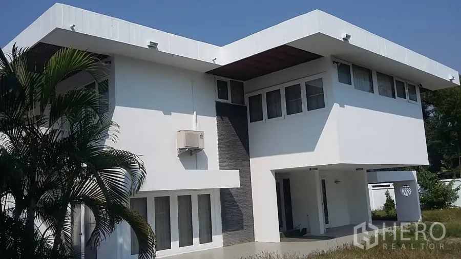 Detached House for rent in Khlong Toei, Bangkok - Front elevation of a contemporary detached home with flat roof and covered carport.