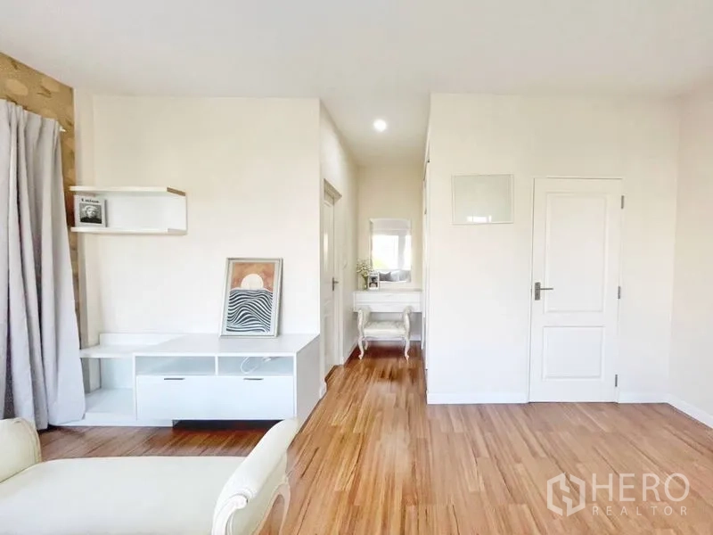 Detached House for rent in Prawet, Bangkok - View of the master suite with built-in TV unit, dressing nook and wood flooring.