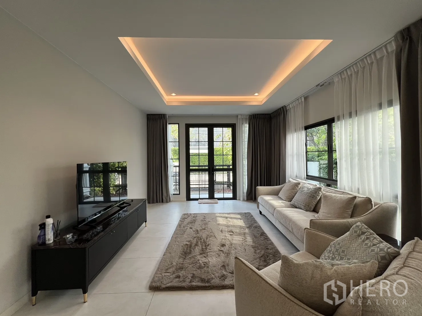 Detached House for rent in Bang Phli, Samut Prakan - Living room with TV console, two sofas and doors to the terrace.