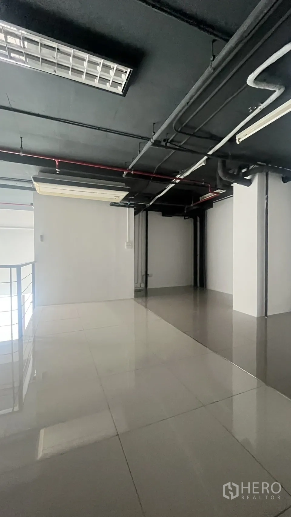 Office Space for rent in Khlong Toei, Bangkok - Spacious mezzanine workspace with polished tile flooring and an exposed black ceiling.