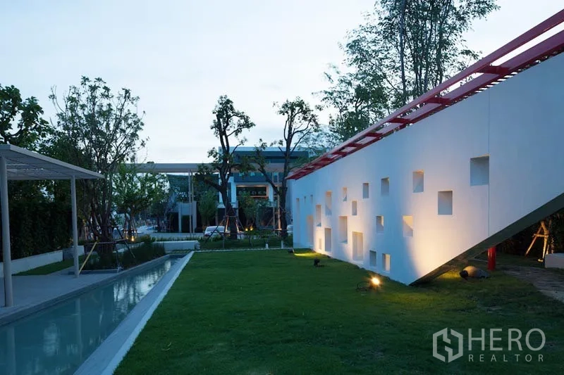 Detached House for rent or sale in Bang Kapi, Bangkok - Evening view of landscaped garden with lit geometric wall and reflecting pool in Bang Kapi home.