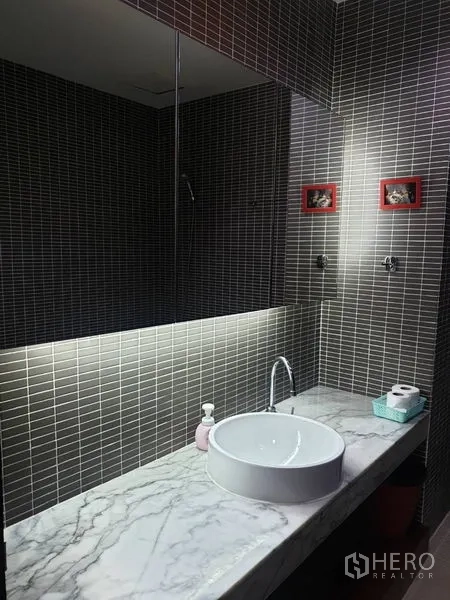 Condominium for rent in Khlong Toei, Bangkok - Modern bathroom with marble countertop, round basin, and large mirror.