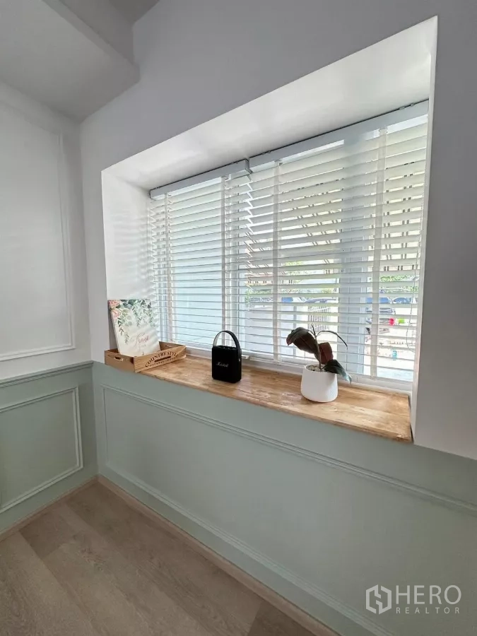 Townhouse for rent in Bang Phli, Samut Prakan - Bright bay window with white blinds and a wooden ledge in the living area.