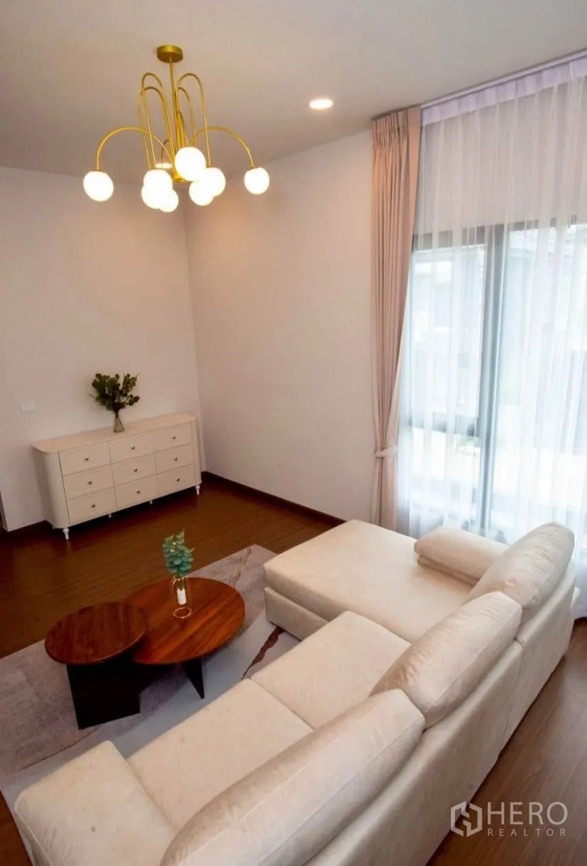 Detached House for rent in Bang Phli, Samut Prakan - Cozy sitting area with sofa, sideboard and floor-to-ceiling drapes.