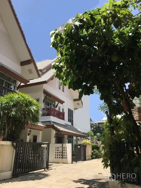 บ้าน ให้เช่าในKhlong Toei, Bangkok - ภายนอกบ้านเดี่ยว พร้อมประตูรั้วและระเบียง ในโครงการร่มรื่น