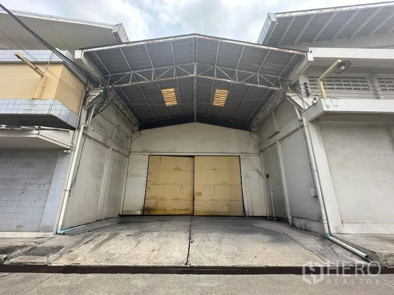 คลังสินค้า ให้เช่าในYan Nawa, Bangkok - ด้านหน้าโกดังพร้อมหลังคาคลุมลานขนถ่ายและประตูเหล็กบานกว้าง เขตยานนาวา กรุงเทพฯ