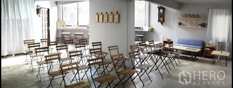 Home Office for rent in Khlong Toei, Bangkok - Open-plan workshop studio with rows of folding chairs, polished concrete floor and a cozy lounge corner.