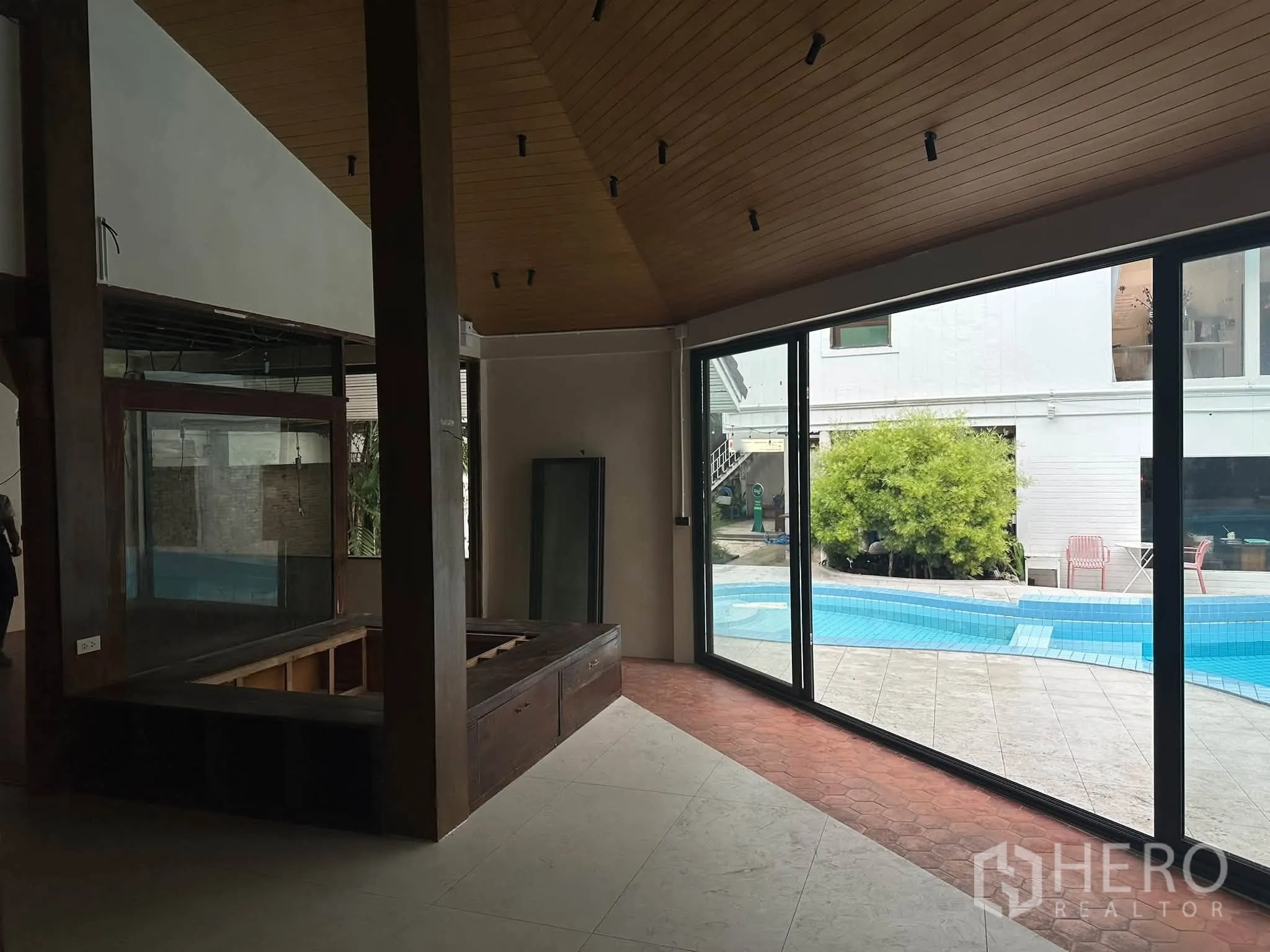 Retail Space for rent in Khlong Toei, Bangkok - Interior space with timber beams and built-in bench overlooking the pool.