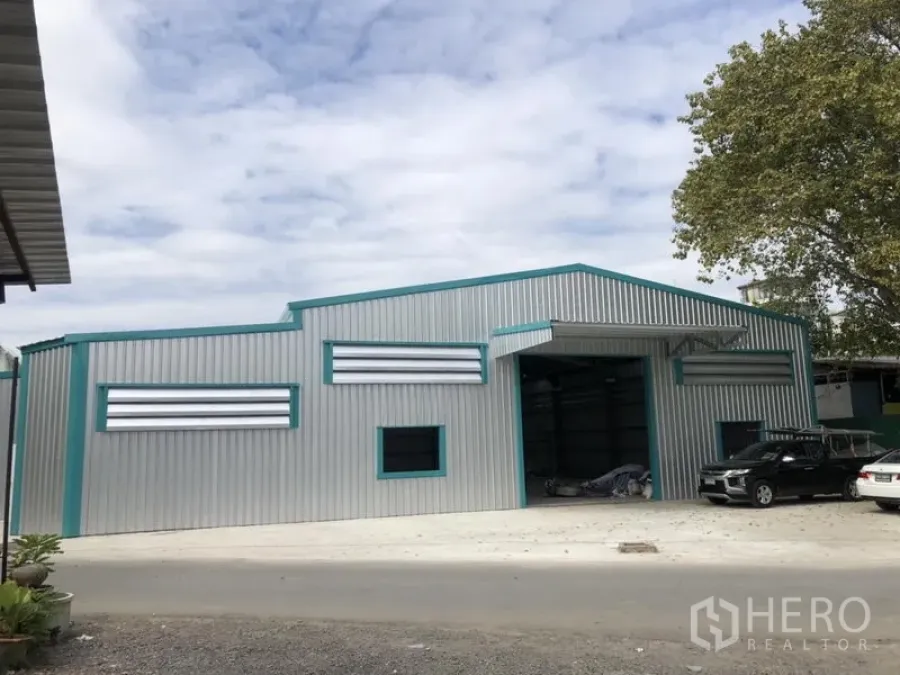Warehouse for rent in Lak Si, Bangkok - Angled view of steel warehouse building with large entry and spacious forecourt.