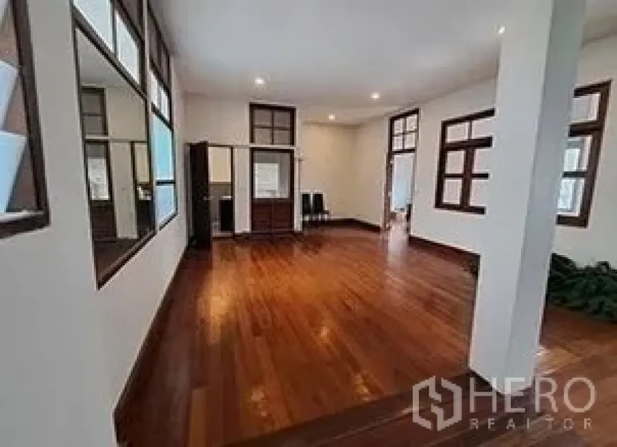 Retail Space for rent in Bangkok - Spacious showroom-style room with hardwood floors, recessed lighting, and window frames.