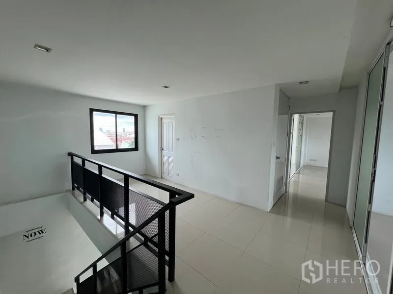 Warehouse for rent in Bang Phli, Samut Prakan - Stair landing with black metal railing, window and corridor to additional offices.