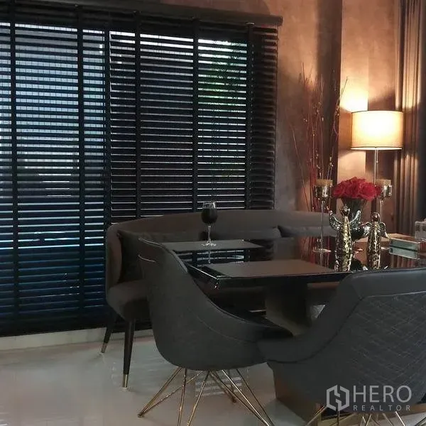 Detached House for sale in Nonthaburi - Elegant dining area with upholstered chairs, black table and large window blinds.