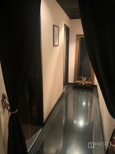 Retail Space for rent in Bang Rak, Bangkok - Narrow hallway with black tile floor, cream walls, draped curtains and a large mirror.