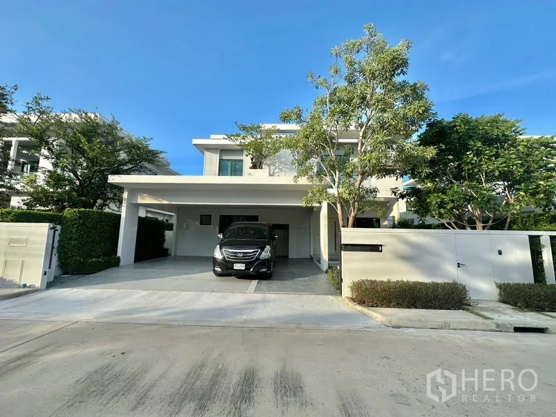 Detached House for rent in Samut Prakan - Modern two-storey detached house in Bang Phli with a covered two-car driveway and a neat front tree.