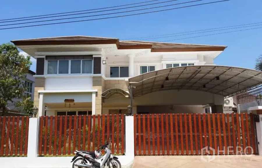 Detached House for sale in Suan Luang, Bangkok - Street-facing facade with red slat fence and expansive roofed carport.