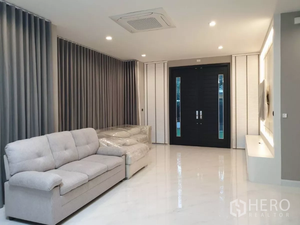 Detached House for rent in Bang Phli, Samut Prakan - Bright living room with grey sofas, marble floors and recessed lighting