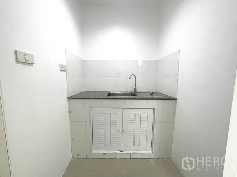 Office Space for rent in Khlong Toei, Bangkok - Compact kitchenette with countertop, sink and storage cabinet.