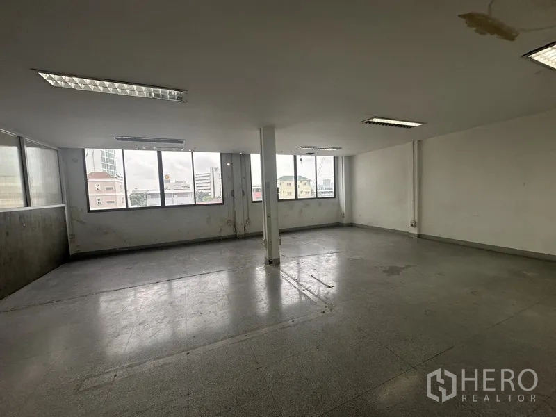 Office Space for rent in Khlong Toei, Bangkok - Corner office with multiple windows, central column and neutral finishes.