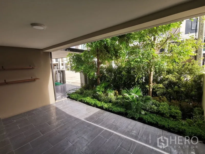 Townhouse for rent in Bang Phli, Samut Prakan - Covered terrace and carport facing landscaped front garden with mature trees.
