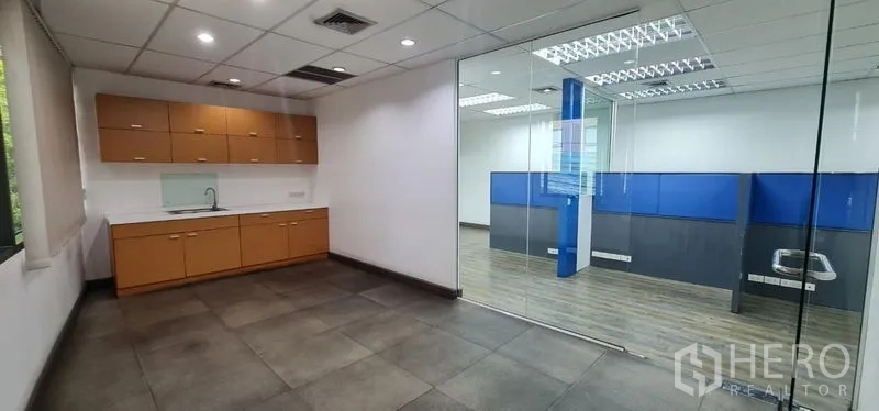 Office Space for rent in Watthana, Bangkok - Pantry adjacent to the office area, seen through a clear glass partition.