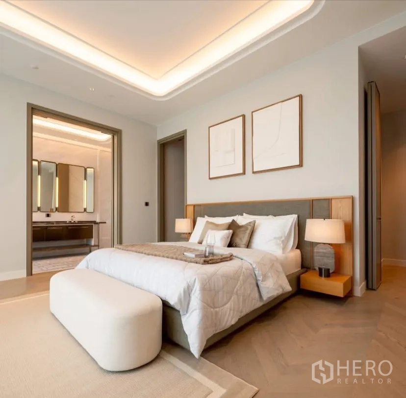 Condominium for rent or sale in Pathum Wan, Bangkok - Primary bedroom with upholstered bed, bedside lamps and direct access to a luxury ensuite.