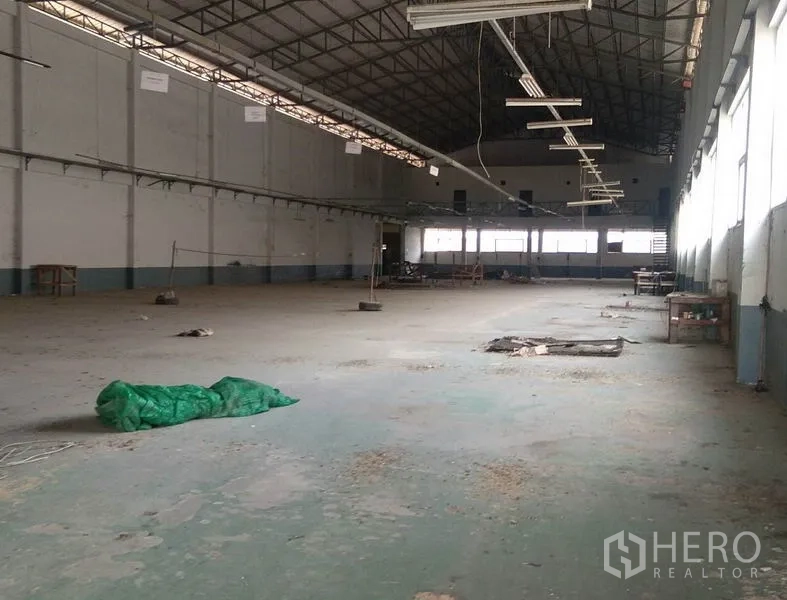 Factory for rent in Bang Phli, Samut Prakan - High‑ceiling factory hall with steel truss roof, long‑span lighting and natural light from windows.
