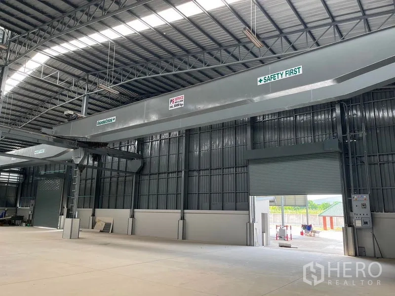 货栈 出租在Bang Phli, Samut Prakan - 仓库内部层高高，设行车梁与天窗，配卷帘门，金属屋顶采光良好。