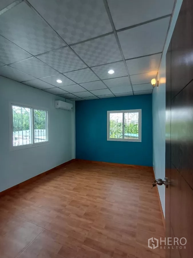 带办公室的家 出租在Phra Khanong, Bangkok - 角落卧室，两扇窗，蓝色重点墙与木地板。