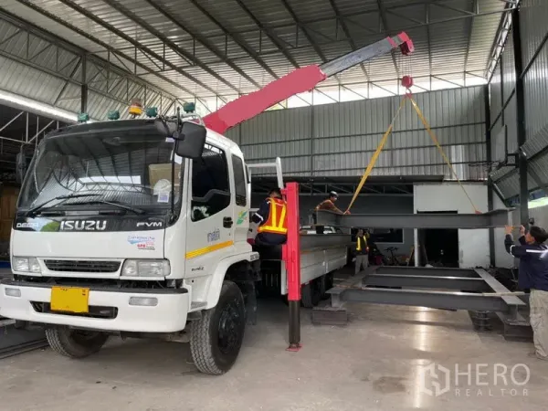 货栈 出租或出售在Khlong Luang, Pathum Thani - 有顶装卸区，起重卡车在仓内吊运钢梁，层高充裕。