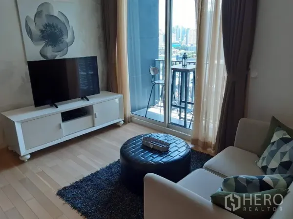 Condominium for rent in Khlong Toei, Bangkok - Cozy lounge facing a balcony bar table with skyline views from a high floor.