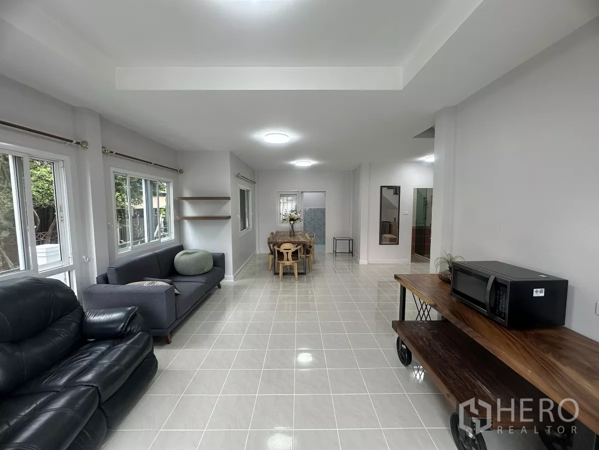 Townhouse for sale in Lam Luk Ka, Pathum Thani - Long living zone facing the dining area, surrounded by windows.