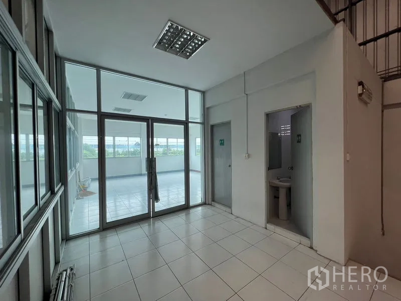 货栈 出租在Lat Krabang, Bangkok - 办公区瓷砖地面，玻璃隔间，附卫生间与阳台入口。
