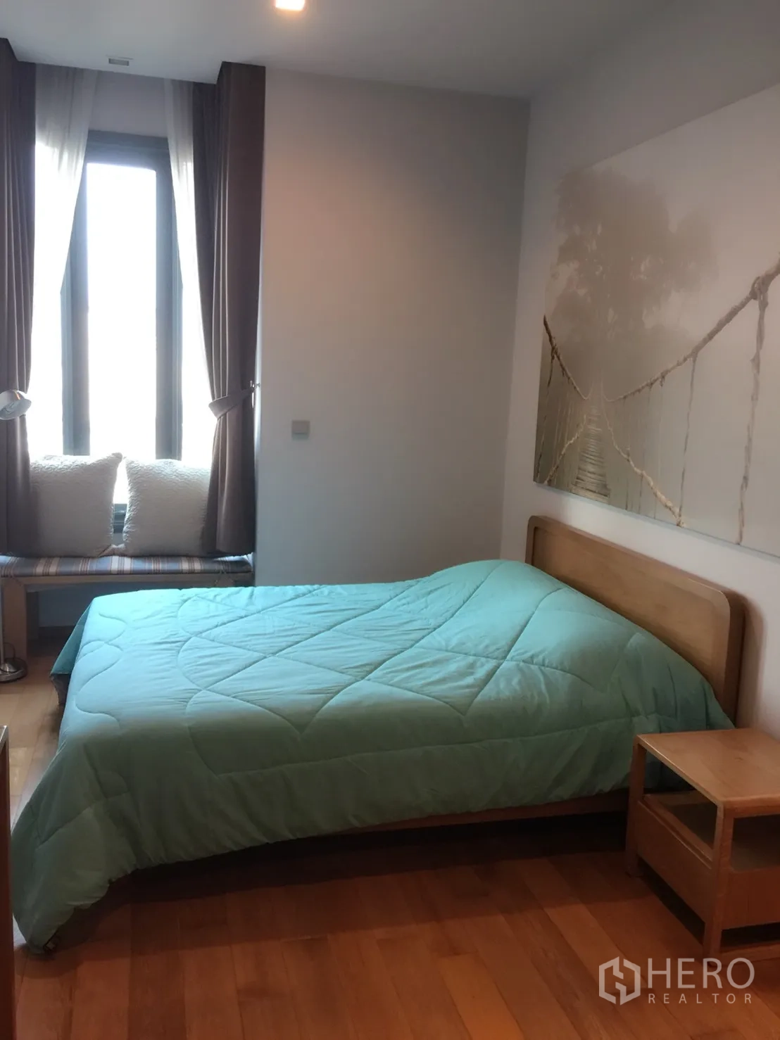 Condominium for rent in Khlong Toei, Bangkok - Cozy bedroom with a large window, blackout curtains, queen bed and bedside table.