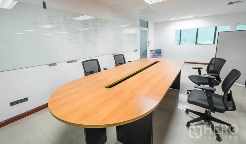 办公空间 出租在Huai Khwang, Bangkok - 会议室配长椭圆桌、人体工学椅和整面白板墙