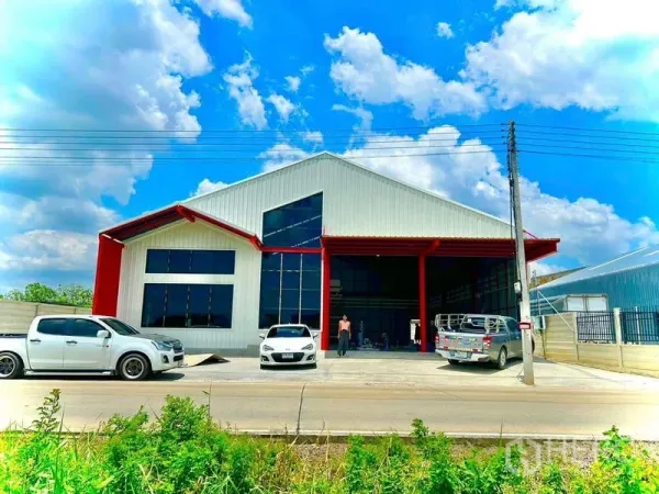 货栈 出租在Lam Luk Ka, Pathum Thani - 仓库正立面，设高挑玻璃窗与带雨棚的装卸区及停车位。