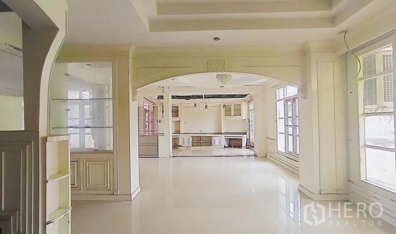 Detached House for sale in Bang Kapi, Bangkok - Open-plan lounge with archways, large windows and light tile floors.