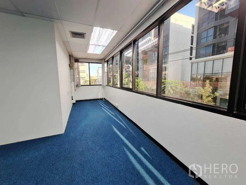 Office Space for rent in Khlong Toei, Bangkok - Bright corridor-style zone with wide corner windows overlooking nearby buildings.