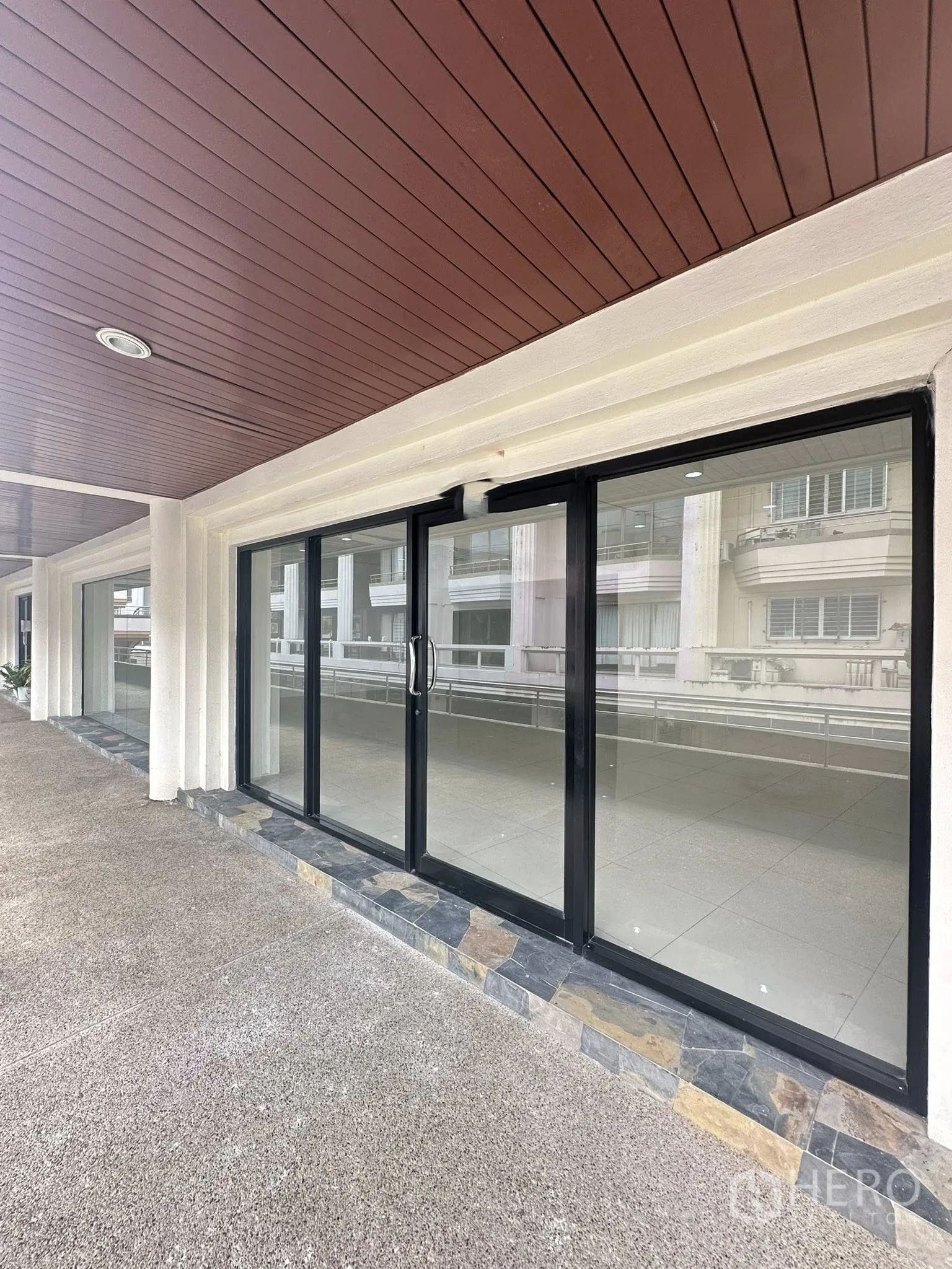 Office Space for rent in Watthana, Bangkok - Black-framed sliding glass entrance beneath a covered walkway.