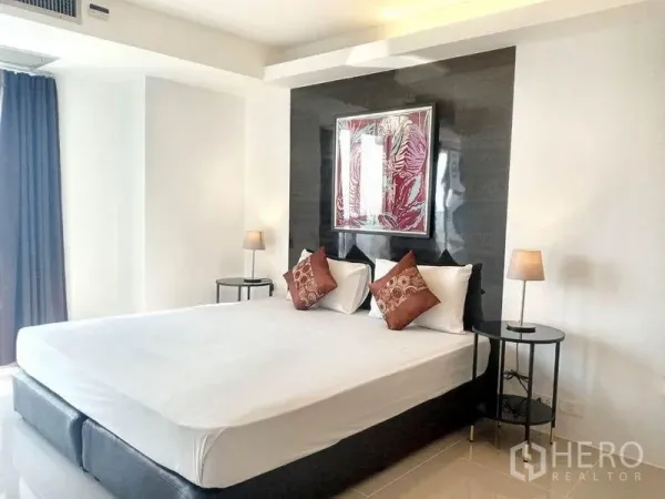 Condominium for rent in Khlong Toei, Bangkok - Master bedroom with king bed, glossy black headboard wall, twin bedside lamps and artwork near BTS Phrom Phong.