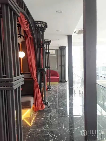 Retail Space for rent - Upper corridor with black frames, red drapes, marble floor and seating alcoves.