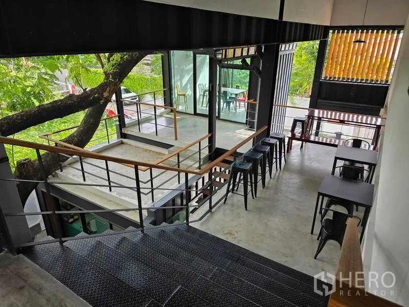 Home Office for rent in Chatuchak, Bangkok - Stair landing with bar seating next to a glass room and garden views.