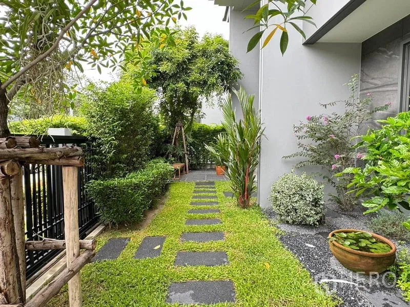 Detached House for rent in Bang Kapi, Bangkok - Lush side garden with stepping stones, privacy fence and layered tropical planting.